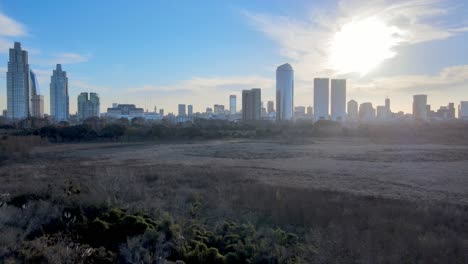 4k aerial drone footage slow low flying over nature reserve in puerto madero with cityscape skyline and beautiful sunset over architectural modern buildings in buenos aires, argentina