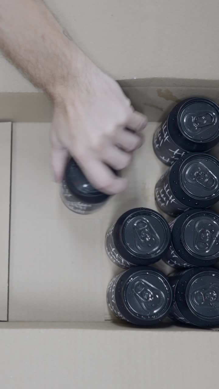 Overhead view of black beverage cans in a cardboard box
