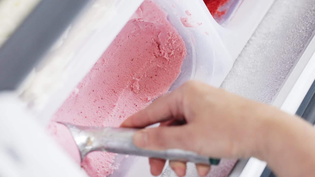 Video verticale di gelato alla fragola testurizzato prelevato con una paletta, Primo piano al rallentatore.
