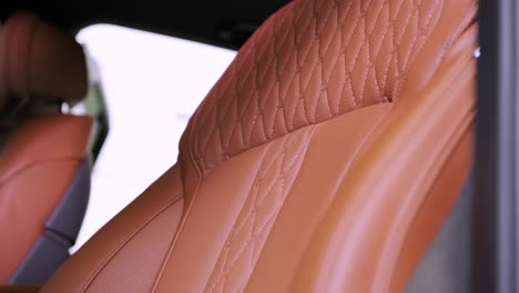 vista cercana del interior de cuero de un coche de lujo, beige. cómodos asientos perforados en un sedán de negocios para un viaje cómodo.