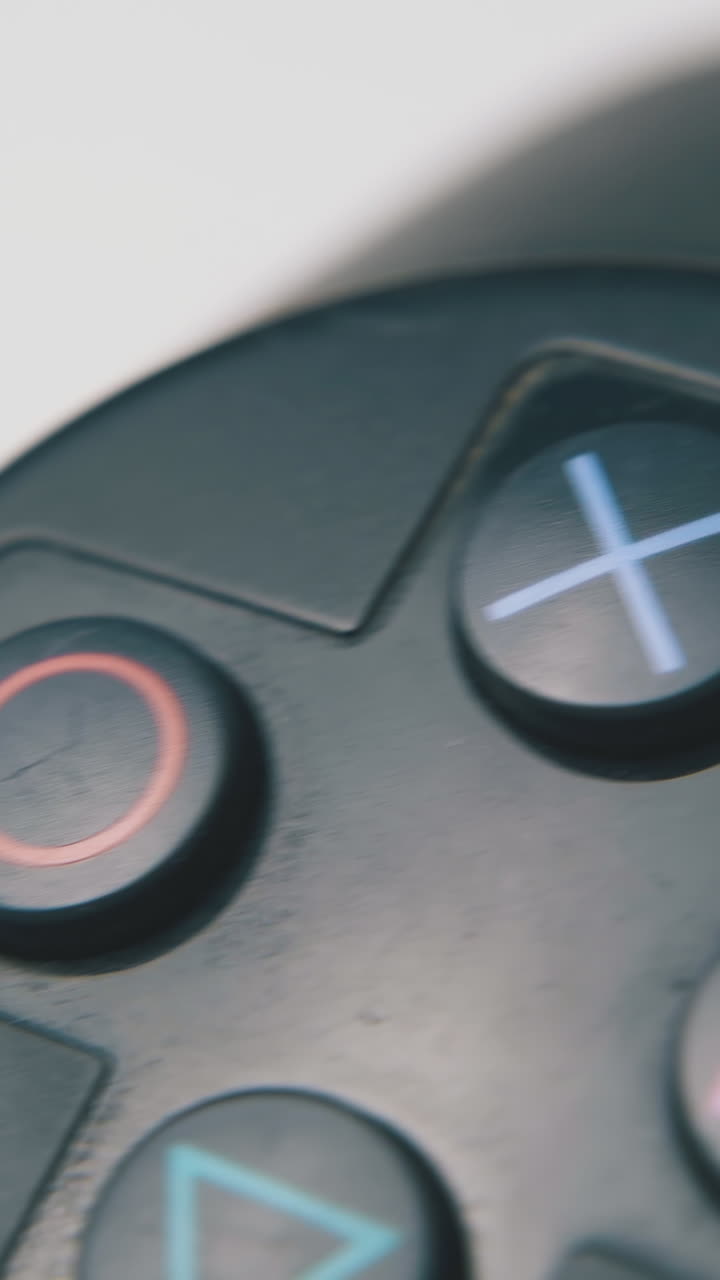 modern joystick with different symbols on buttons for video games playing on light surface macro