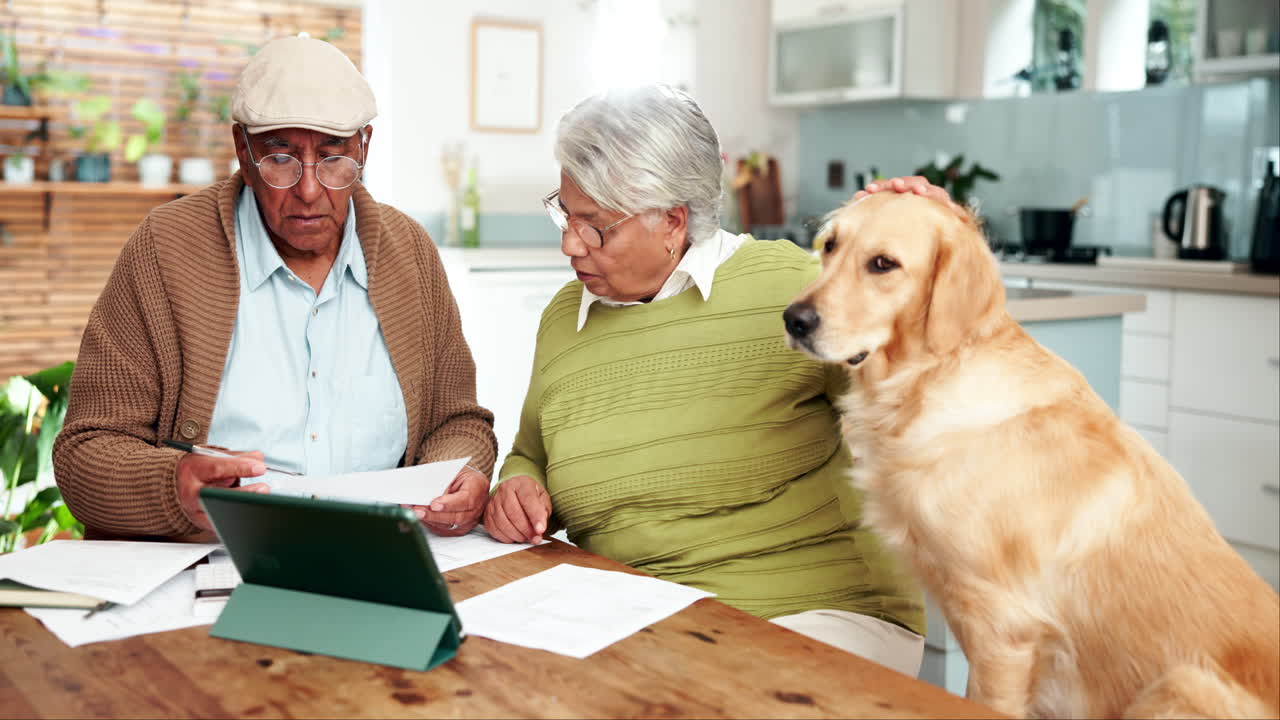 Coppia anziana con il loro cane che esamina le finanze a casa
