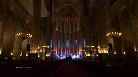 Interior-of-majestic-Cathedral-of-Barcelona-with-glowing-lights-for-concert,-dolly-forward