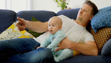 Padre-Y-Bebé-Viendo-Televisión-En-La-Sala-De-Estar-4k