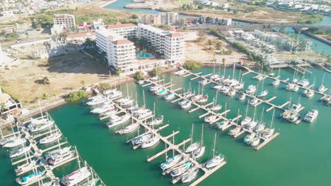 jib down of boats docked in harbor in front of luxurious hotel in sunny mexico