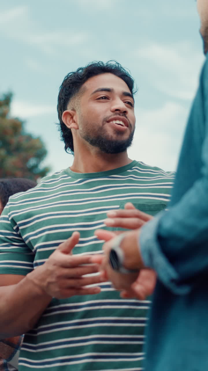 Young Man Talking, Laughing, and Clapping Hands Outdoors