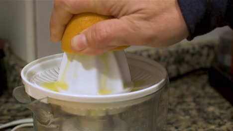 using an orange juicer in the kitchen