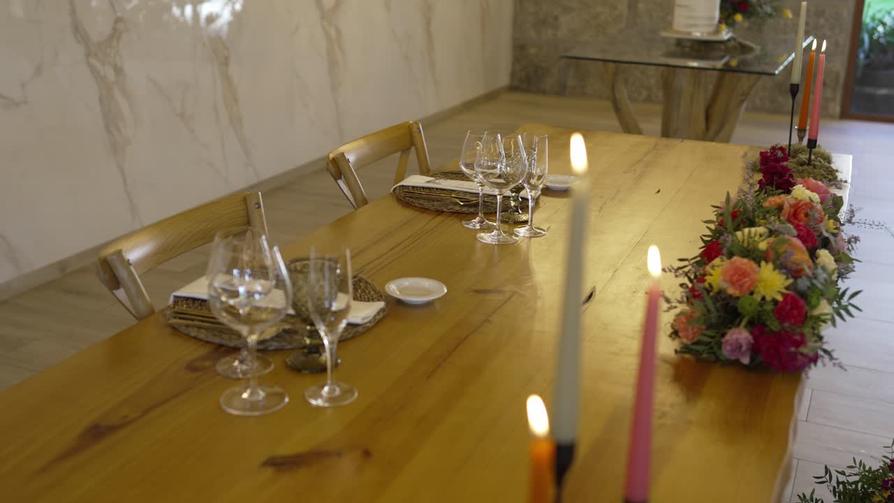 wedding table with candles glassware and floral centerpiece in a rustic indoor venue