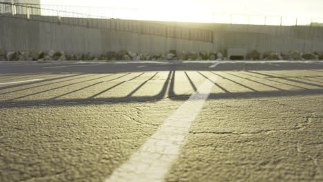shadows cast over an empty parking lot during late afternoon light