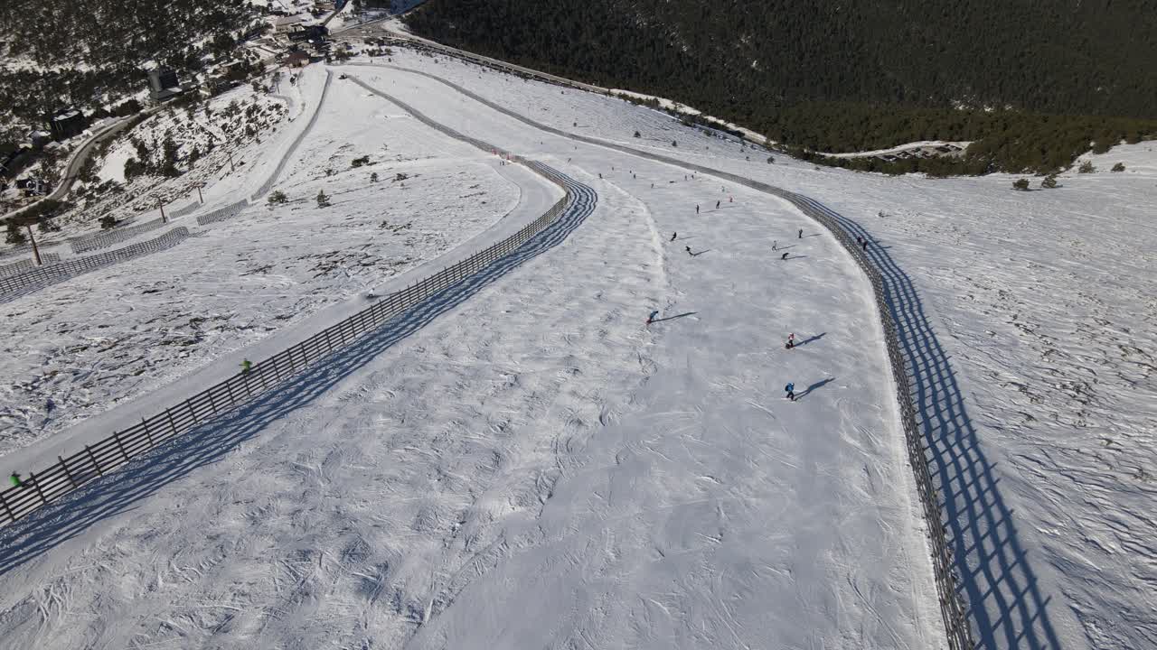 vista aérea de una estación de esquí en navacerrada, madrid, con gente esquiando en la pista