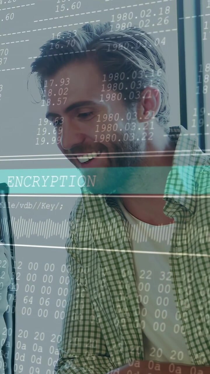 Vertical video: Woman tapping laptop, man leaning, reviewing encrypted data with ENCRYPTION band