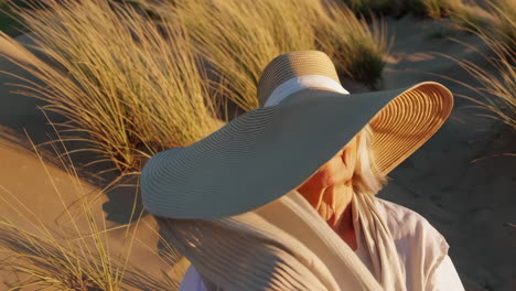 an elderly woman enjoying the golden hour on sand dunes