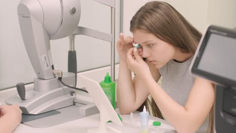 young girl place the contact lens in the front from the mirror with doctor. inserting contact lens. night time contact lenses