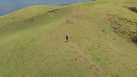 un disparo de boomerang de un hombre mirando hacia la vista del paisaje de batanes