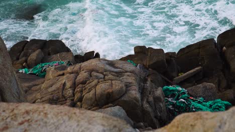 trash stacked on coastal rocks and drifting on sea waves, water pollution crisis