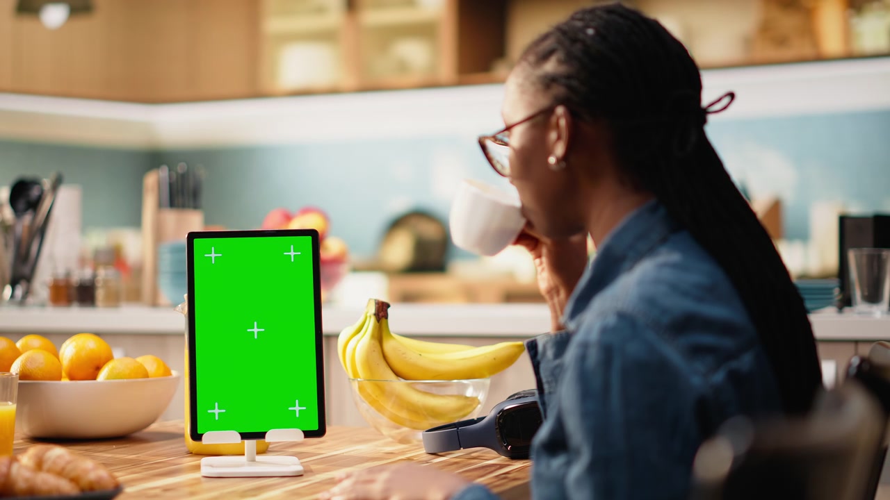 Mockup verticale con schermo verde su tablet in cucina su tavolo di legno