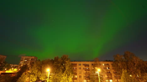 Coloridas-Luces-Verdes-Del-Norte-Sobre-Edificios-Suburbanos-De-La-Ciudad-Post-Soviética,-Lapso-De-Tiempo