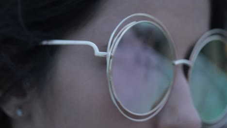 girl posing wearing with big round sunglasses at night in the evening