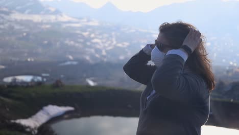 woman wearing a mask in the nature in front of a lake, close up