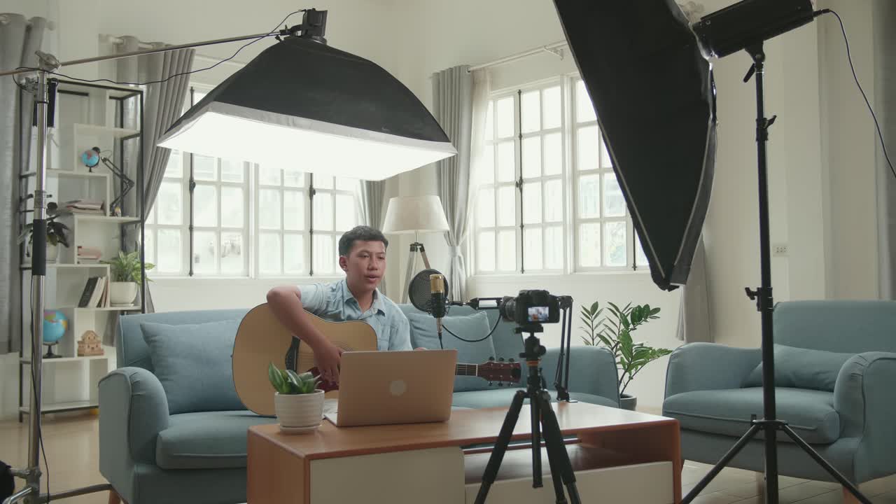 Teenager Playing Acoustic Guitar and Recording Music at Home