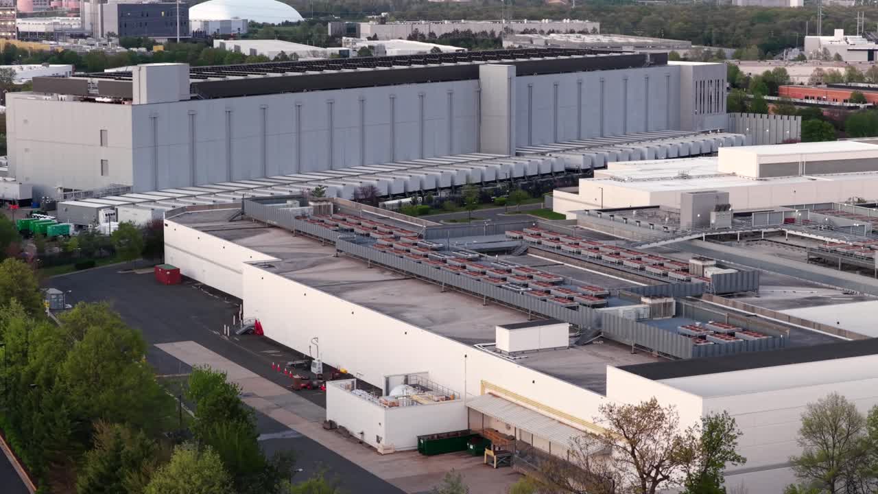 Luftfoto af et stort datacenterkompleks i Ashburn, Virginia, med store industribygninger, køleinfrastruktur på taget og serverfaciliteter, der driver cloud computing og digitale netværk