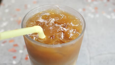 close-up of a glass of iced tea with a straw