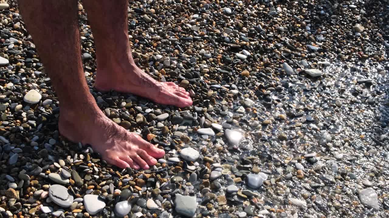 바위 해변 에 있는 물 에 발 을 는 것