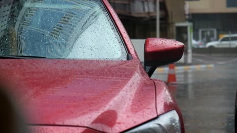 shiny red luxury car parked under a slight rain drizzle in dubai, uae