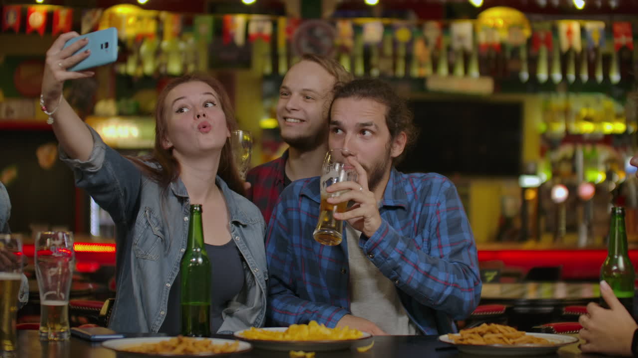uomini tempo libero amicizia e concetto di tecnologia - amici maschi felici che bevono birra e si fanno selfie con lo smartphone in un bar o in un pub