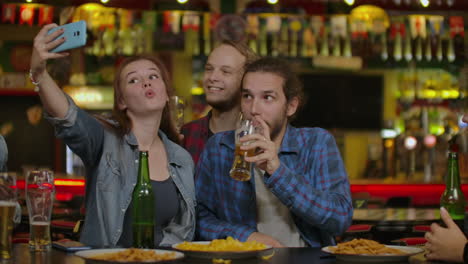 hombres ocio amistad y concepto de tecnología - amigos varones felices bebiendo cerveza y tomando selfies con su teléfono inteligente en un bar o pub