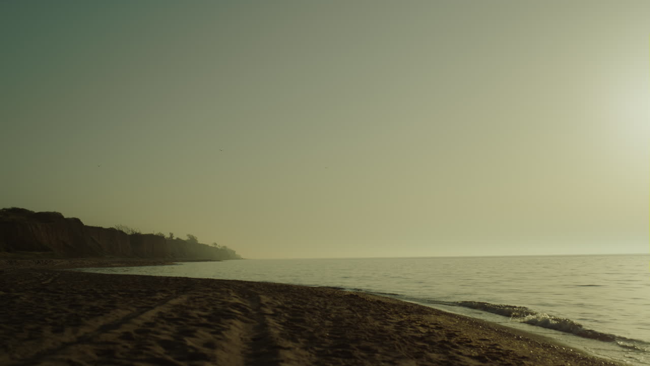 Splendida vista di spiaggia sabbiosa all'alba. Mattinata scenografica nella natura vicino all'oceano calmo.