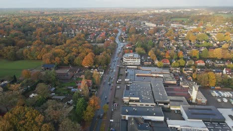 high aerial of traffic driving over a long road trough a small town in the netherlands