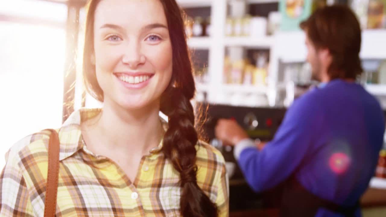 Beautiful woman holding coffee and croissant at counter