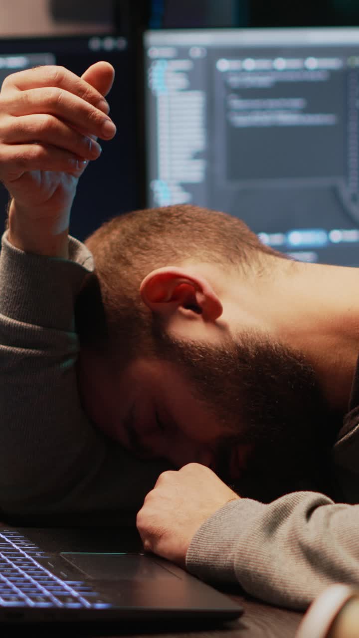 Vertical video: Programming engineer falling asleep on office desk