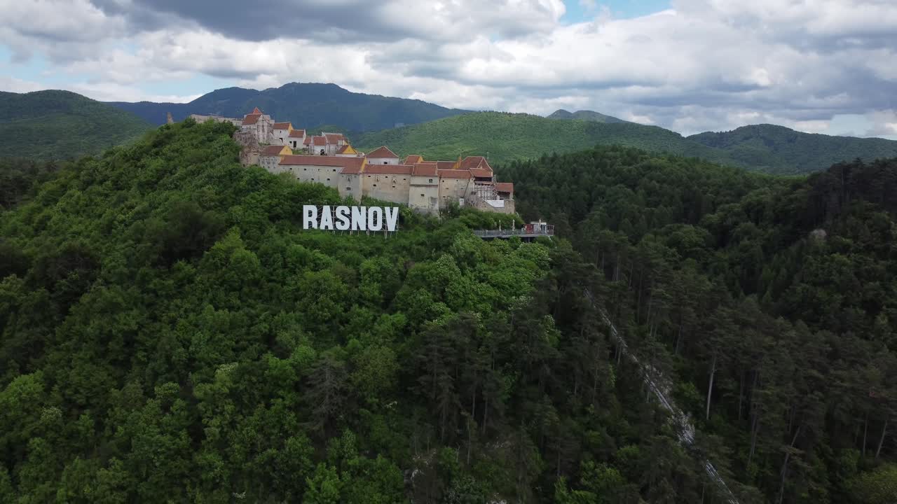 Orbiting 4K drone shot of Rasnov hilltop town in the Carpathian mountains, Transylvania, Romania