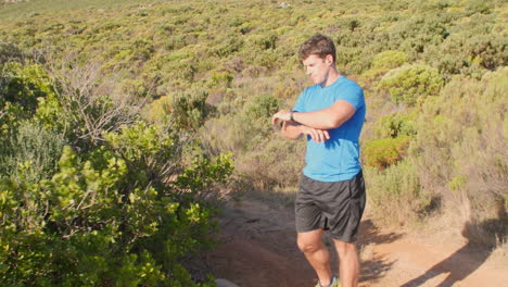 un corredor masculino comprobando el tiempo en su reloj deportivo antes de correr