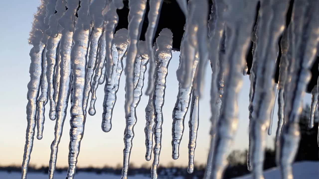 Close-up video of icicles hanging from a roof, captured from a low angle