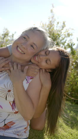 vertical video: smiling grandmother and granddaughter hugging outdoors, enjoying quality family time