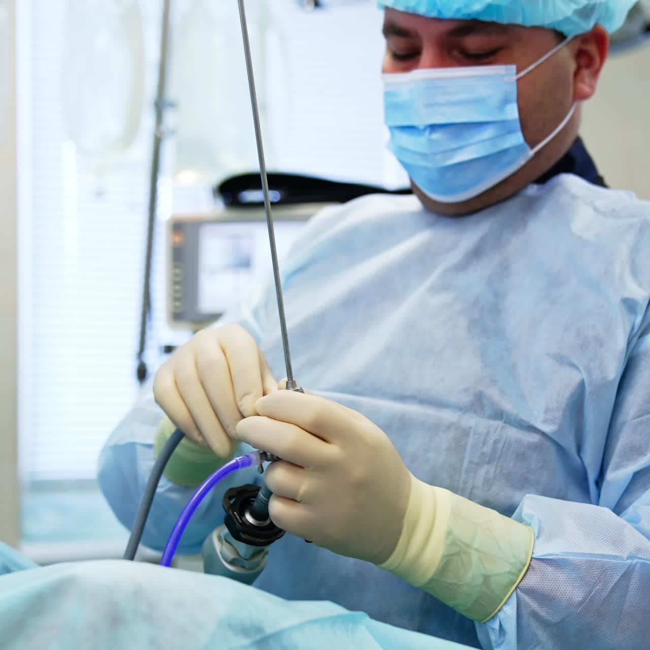 Doctor holding innovative equipment for surgery intervention. Thin tube starts to lamp and surgeon adjusts it to the device