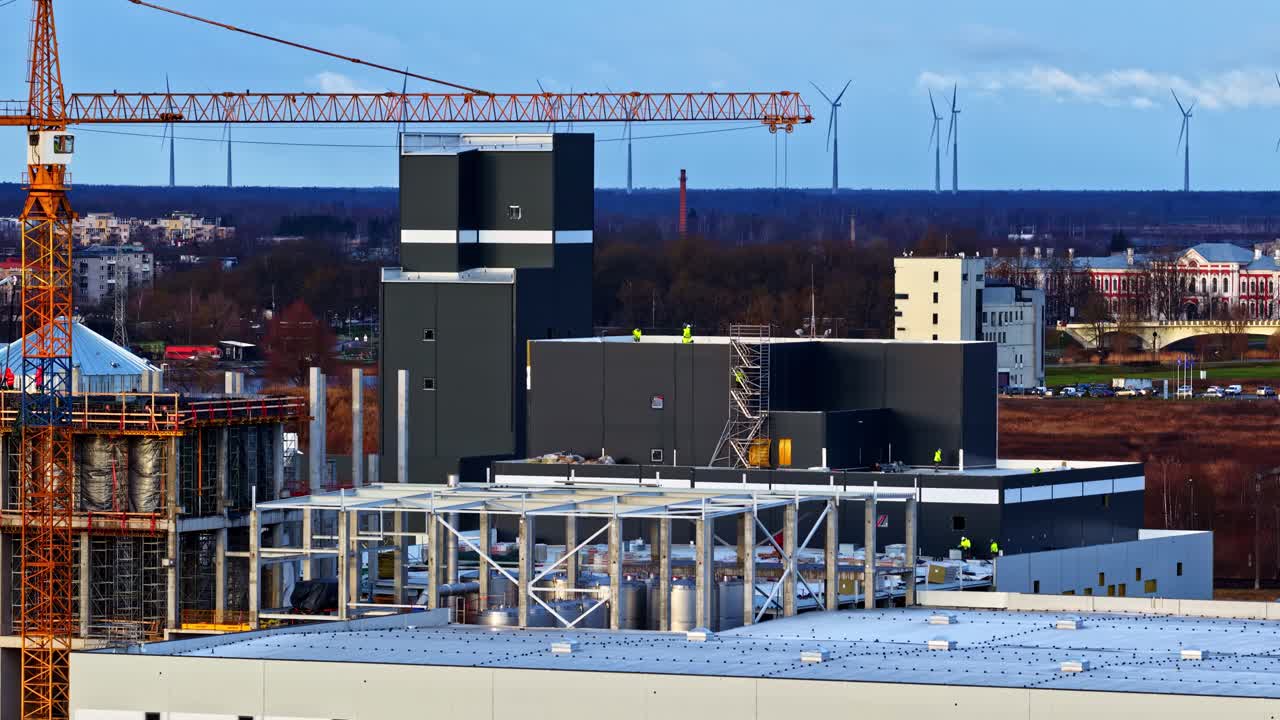 Industrial landscape with wind turbines and cranes; calm and productive scene