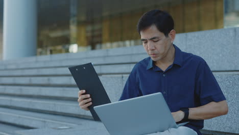 man working on laptop outdoors