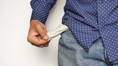 El joven muestra el bolsillo del pantalón vacío con espacio para copiar.
