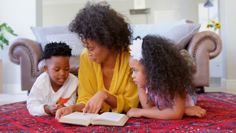 Vorderansicht-Einer-Schwarzen-Mutter-Mit-Ihren-Kindern,-Die-In-Einem-Komfortablen-Zuhause-Ein-Buch-Liest,-4k
