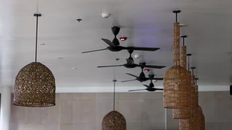 ceiling fans spin slowly in a well-lit restaurant, highlighting modern decor and ambient lighting