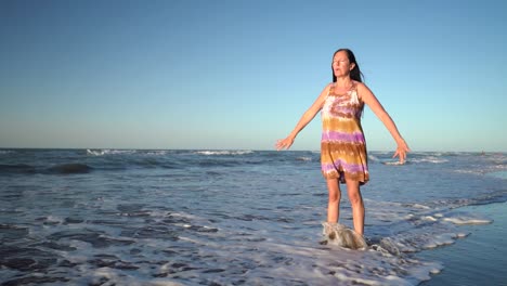 Middle Aged Woman Doing Breathing Exercise On The Beach - wide shot