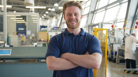 portrait of male engineer walking towards camera in workshop