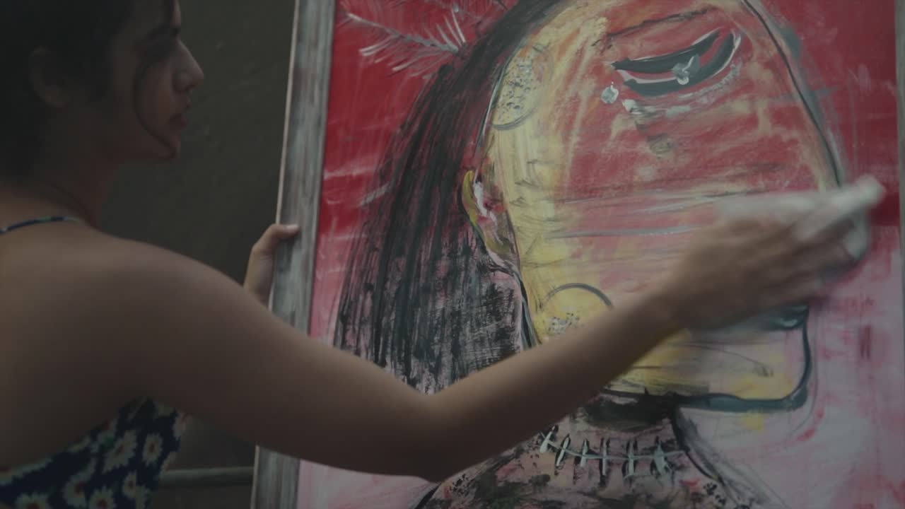 아름다운 소녀가 그림을 청소하고 있습니다.