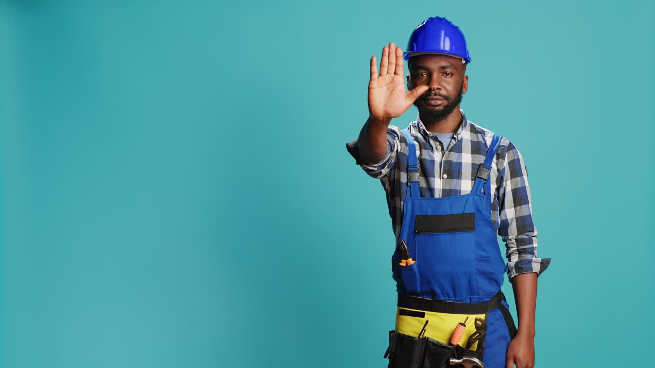 Construction worker raising hand doing stop sign