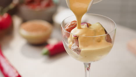 preparing a spicy salmon cocktail with a creamy sauce