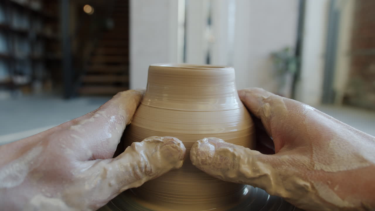 Hands Shaping a Clay Pot on a Pottery Wheel